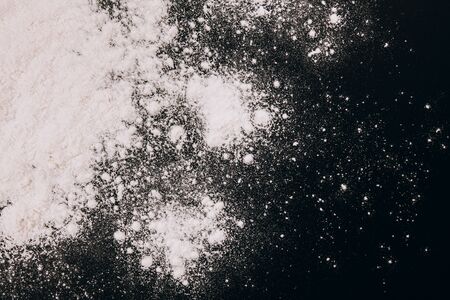 Scattered flour for baking or pasta on black backgroundの写真素材