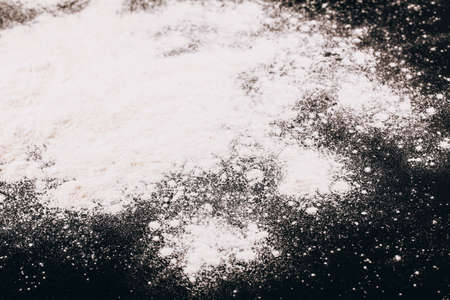 Scattered flour for baking or pasta on black backgroundの写真素材