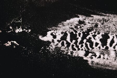 Flour are scattered in a striped pattern on black , zebra 
