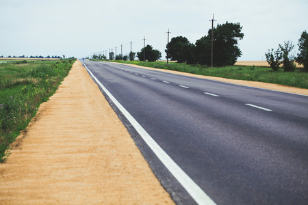 White dividing line on the road surface with the roadsideの写真素材