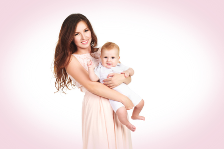 A loving mother in a dress hugs a young child isolatedの写真素材