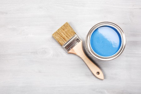 Copyspace with paintbrush and can with blue paint lying on white wooden clean table.の写真素材