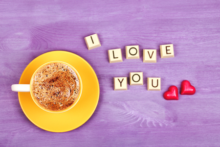 Coffee and chocolate sweets I LOVE YOU over violette bright wooden background.の写真素材