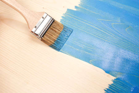 Painting natural wood with paint brush in blue color.の写真素材