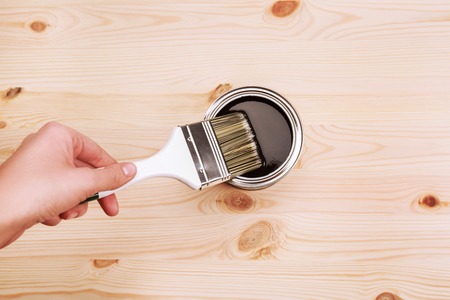 Hand painting grey color on wooden table. House renovation.の写真素材