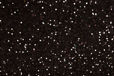 Glamour black sparkling background. Blured glitter background with blinking stars. Holiday abstract texture.の写真素材