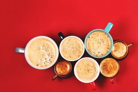 Many different cups of coffee and cappuccino on red backgroundの写真素材