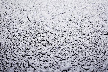 Water drops of dark stone water-repellent surface. Natural macro background