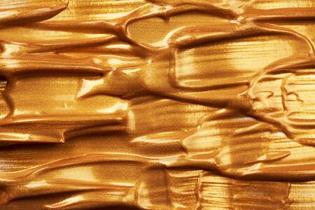 Golden shining stroke texture made with brush and paint hand drawn. Golden abstract background....