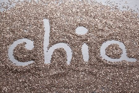 Chia seeds with text "Chia", lying on dark stone background.の写真素材