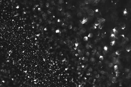 Glamour black sparkling background. Blured glitter background with blinking stars. Holiday abstract texture.の写真素材