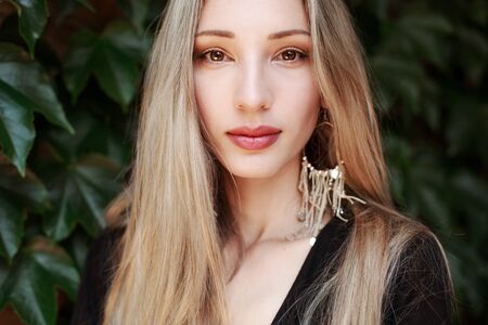 Outdoor portrait of beautiful young woman with perfect skin, long hair, brown eyes and full lips.の写真素材