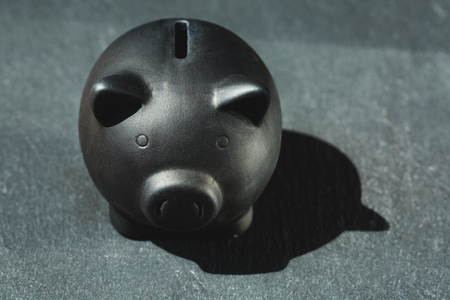 Black satine piggy bank on black stone background.の写真素材