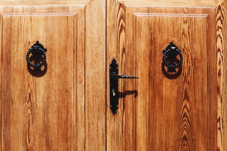 Old wooden door with bright texture on Mallorca, Spain. Metal hand, old knocker.の写真素材