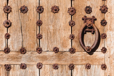 Old wooden door with bright texture on Mallorca, Spain. Metal hand, old knocker.の写真素材