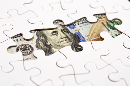 Collecting 100 dollars banknote with pieces of jigsaw puzzle. Concept of teamwork for sucsess.の写真素材
