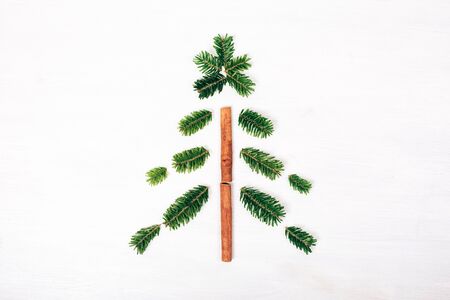 Christmas tree made of fir branches. White wooden rustic background. Winter flat lay style picture.の写真素材