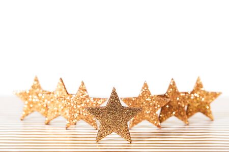 Group of textured glittering golden stars on festive background.