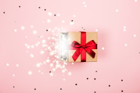 Present with red bow and magic inside.の写真素材