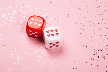 Two dices with hearts on pink backgroundの写真素材