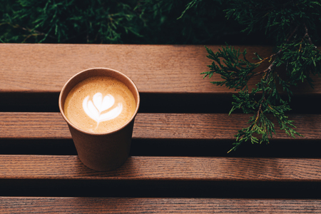 Paper cup of Coffee take-away, top view. Wooden table and place for text.の写真素材