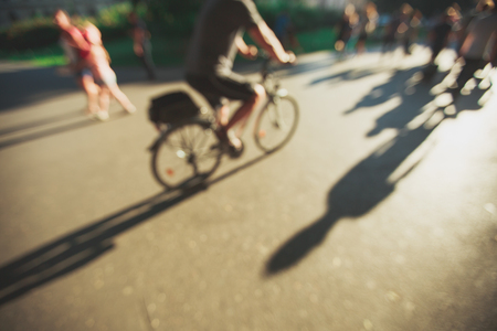 Blurred people background in magic sunset light with long shadows.の写真素材