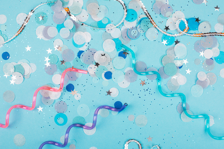 Blue pastel festive background with sparkles and confetti. Flat lay style.の写真素材