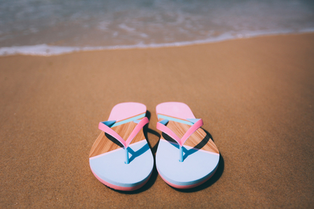 Trendy slippers on the sandy beach.の写真素材