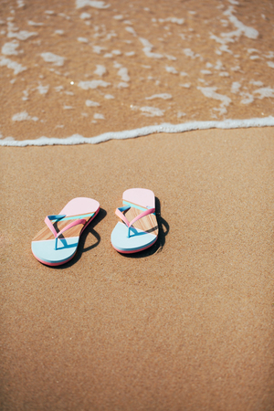 Trendy slippers on the sandy beach.の写真素材