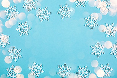 White toy snow flakes on blue background.の写真素材