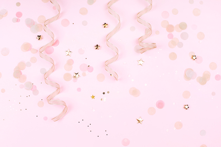 Golden decorations on pink pastel background.の写真素材