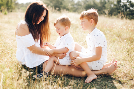 Portrait of a young mother with her two sons outdoorの写真素材