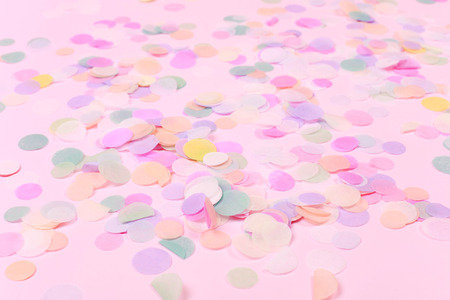 Vibrant confetti on pastel pink backgroundの写真素材