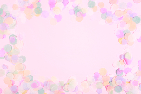Vibrant confetti on pastel pink backgroundの写真素材