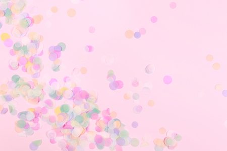 Vibrant confetti on pastel pink backgroundの写真素材