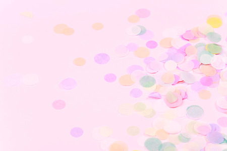 Vibrant confetti on pastel pink backgroundの写真素材