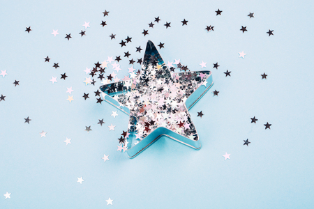 Star with sparkles and shape for gingerbread on blue pastel background. Flat lay style. Concept of celebrating new year. Christmas mood.の写真素材