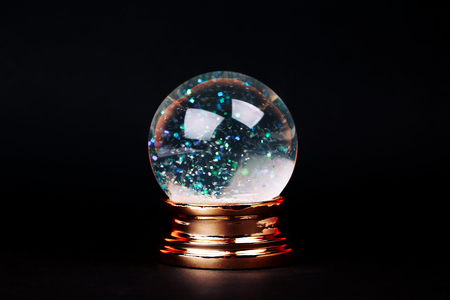 Beautiful snow ball with snowfall inside over black background.の写真素材