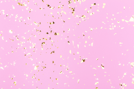 Golden sparkles on pink pastel trendy background. Festive backdrop for your projects.の写真素材