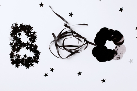 Word Boo is made from silver stars confetti and black decor. Halloween party concept. Flat lay style. Top view.の写真素材
