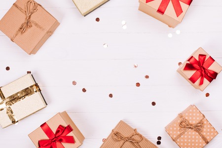 Christmas craft gift boxes with glitter create round frame on white wooden background. Place for text. Festive concept.の写真素材