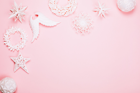Different white beautiful christmas toys creating frame on pink pastel background. Place for text. Festive concept.の写真素材