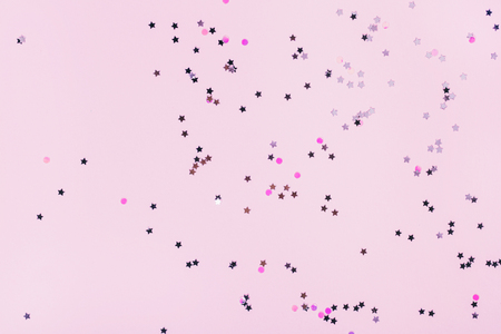 Pink background with multicolored sparkles on it. Festive concept.の写真素材