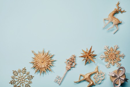Golden beautiful sparkling christmas decoration on pastel blue background. Place for text. Festive concept.の写真素材