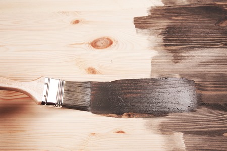 Grey color painting on wooden table or fence or wall, or flour, use for home decorated. House renovation. Half - painted surface. Smear of paint brush.の写真素材