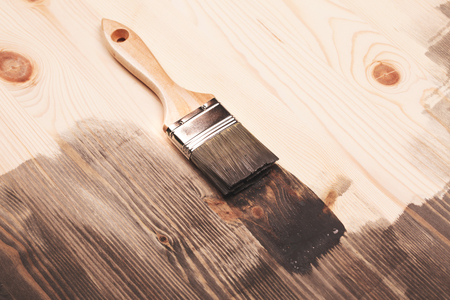 Grey color painting on wooden table or fence or wall, or flour, use for home decorated. House renovation. Half - painted surface. Smear of paint brush.の写真素材