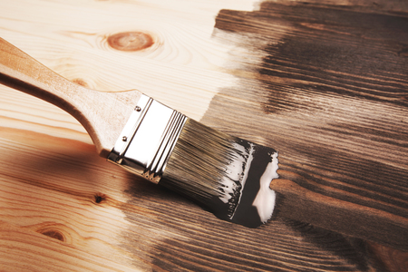 Grey color painting on wooden table or fence or wall, or flour, use for home decorated. House renovation. Half - painted surface. Smear of paint brush.の写真素材
