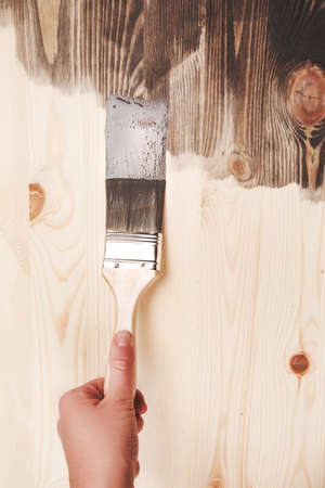 Grey color painting on wooden table or fence or wall, or flour, use for home decorated. House renovation. Half - painted surface. Smear of paint brush.の写真素材
