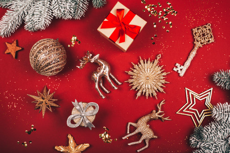 Christmas decorative toys: deers, stars, key, ball, present and glitter on red background. Flat lay styleの写真素材