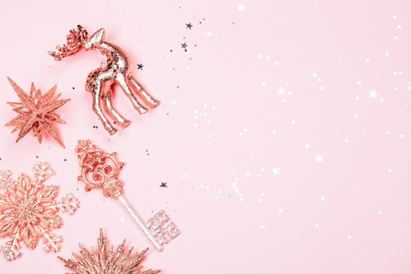 Golden beautiful sparkling christmas decorative toys on pastel pink background. Place for text. Festive concept.の写真素材